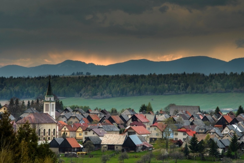 Pohľad na Liptovskú Kokavu z výšky – zástavba, kostolná veža a zelené kopce